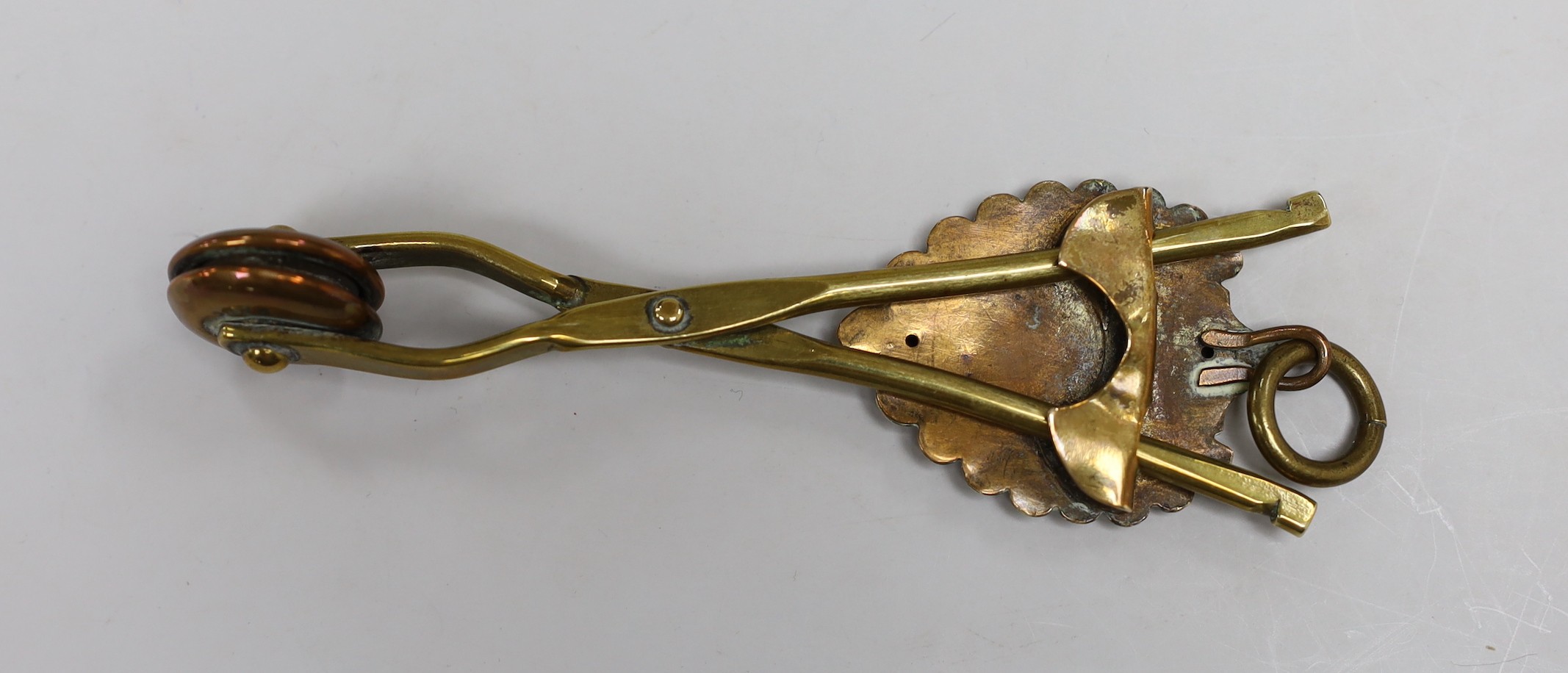 A brass skirt hem lifter. 14cm long